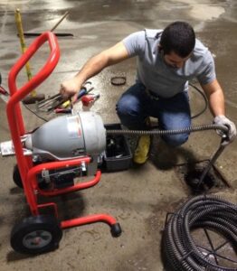 Drain snaking service removing blockage from household drain pipe